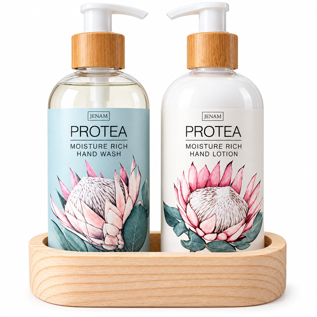 Two pump bottles from the brand JENAM, PROTEA, displayed in a light wood tray. The left bottle is a clear hand wash with a light blue label featuring a protea flower, and the right bottle is a white hand lotion with a white label featuring a pink protea flower.