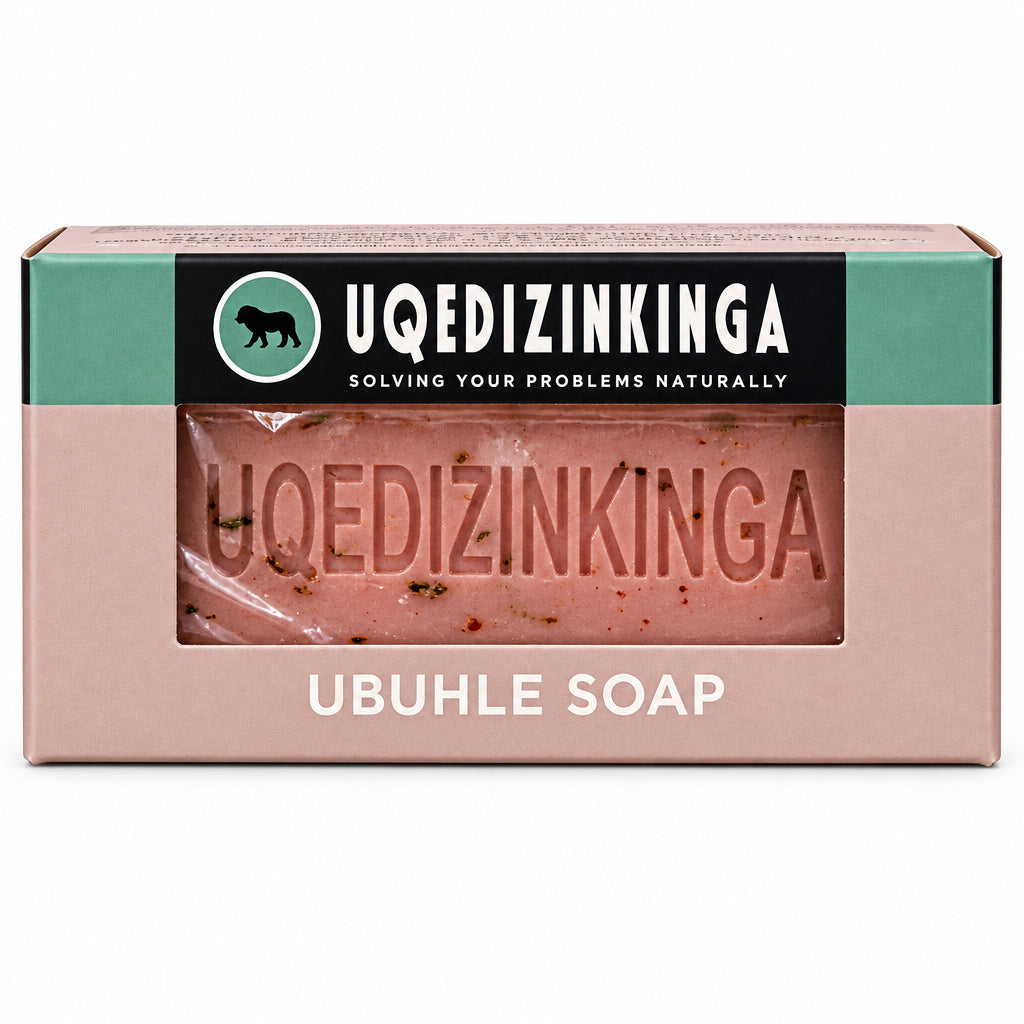 A boxed bar of Uqedizinkinga Ubuhle Soap, showing the pink soap bar through a clear window on the front of the packaging, set against a solid black background.